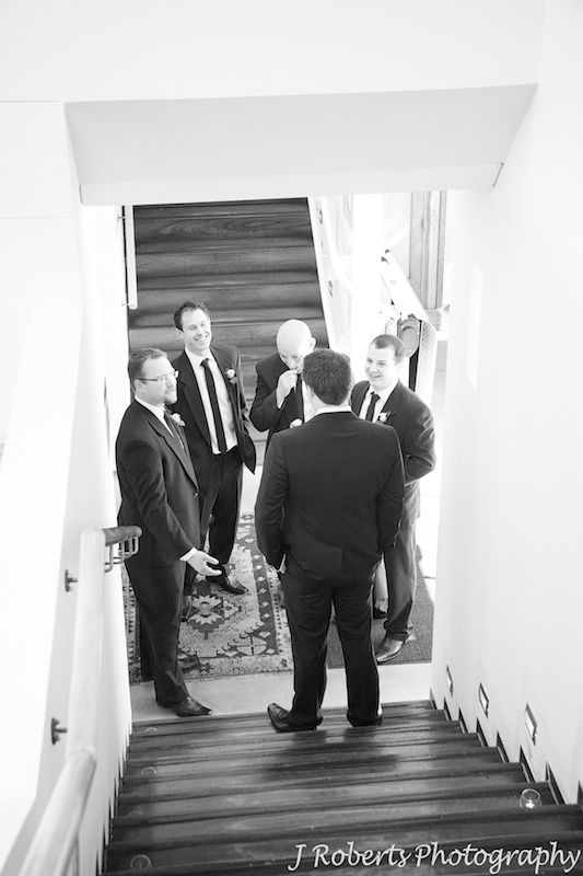 Groom getting a pep talk from his groomsmen pre wedding - wedding photography sydney